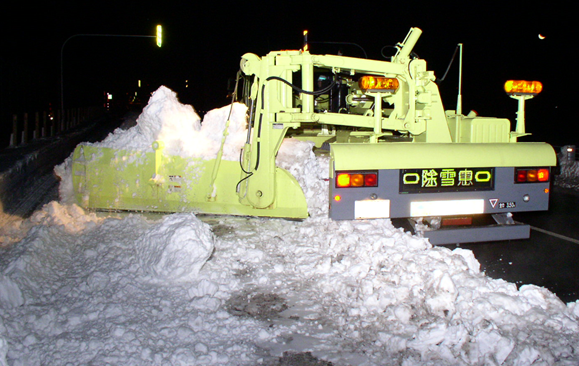 除雪トラック（マックレー装置）にて雪堤を車道側に切り崩している状況
