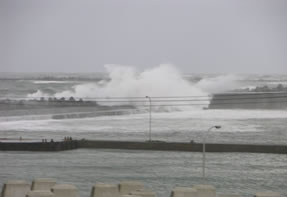 波が防波堤を越えて港内に侵入している状況