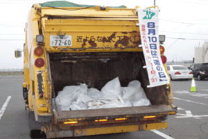 拾い集めたゴミなどを収集車に