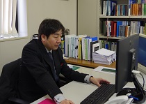 パソコンで作業中の村井さんの写真