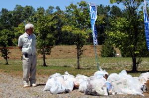 集めたゴミを前に活動の大切さを話す山本帯広河川副所長