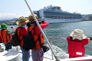 船上から海を眺める見学者