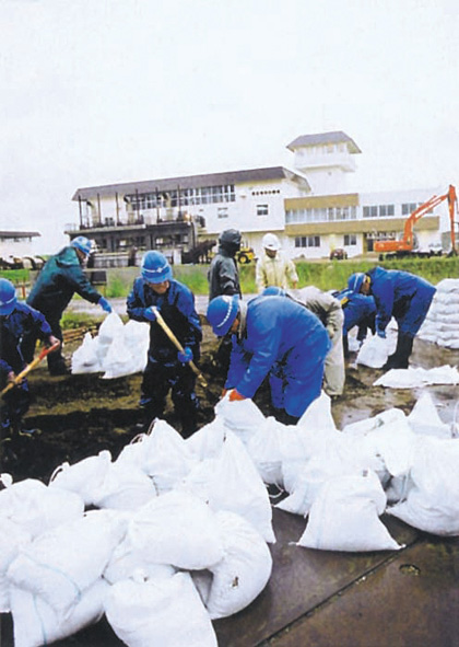 越水に備えて土のうづくりをする長沼町民（石狩川開発建設部蔵）