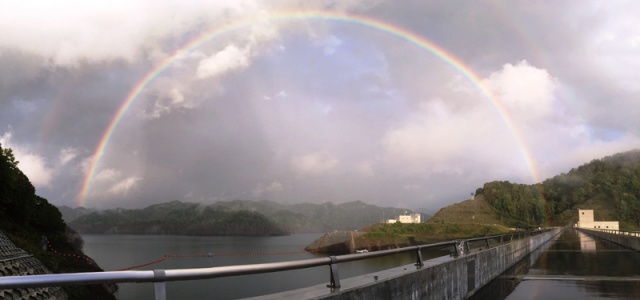 雨上がりの堤頂にかかる虹写真