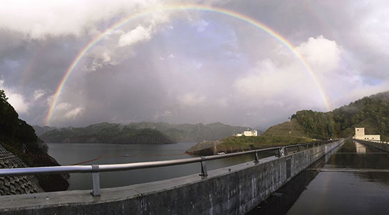 雨上がりの堤頂にかかる虹